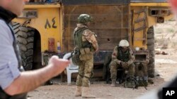 FILE - Russian soldiers stand guard in the ancient city of Palmyra in the central Homs province, Syria, April 14, 2016. Two Russian servicemen were killed and a third wounded in Syria, the Russian Defense Ministry announced Tuesday. 