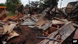 Distorted corrugate panels are scattered among debris of a burnt building in Thandwe, Rakhine State, western Burma, Oct. 2, 2013.