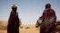 Women wait to load their carts with bags of rice and bottles of cooking oil at a food distribution center run by the Spanish NGO Accion contra el Hambre (Action Against Hunger) in Tarenguel, Gorgol region, Mauritania, May 30, 2012.