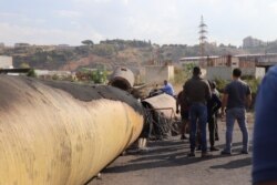 Demonstrators block roads with giant sewage pipes they say come from abandoned factories that have left many locals jobless, outside of Tripoli, Lebanon, Nov. 15, 2019. (Heather Murdock/VOA)