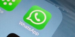 A Whatsapp icon is seen on a smartphone.
