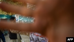 FILE - A member of the Taliban blocks the camera with his hand, in Kabul, Afghanistan, Sept. 30, 2021. The Taliban announced in October 2024 that taking images of living beings violated its morality law. Media in three Afghan provinces has been ordered to obey the rule.