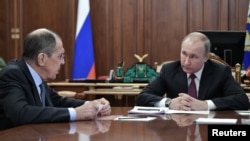 Yayin da shugaba Putin (dama) ke tattaunawa da ministan harkokin wajen Rasha, Sergie Lavrov (hagu)
