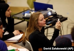 Gwyneth Glissmann of Boulder, Colorado, uses a special device to answer a question in the physics class of Professor Michael Dubson at the University of Colorado in Boulder, Colorado during his lecture.