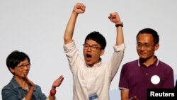 Student leader Nathan Law (C) celebrates on the podium after his win in the Legislative Council election in Hong Kong, China, Sept. 5, 2016. 
