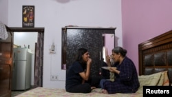 Jashandeep Kaur, 22, talks to her mother Ripudaman Kaur, 52, as they eat at their house in Dera Bassi, India, August 14, 2022. REUTERS/Anushree Fadnavis