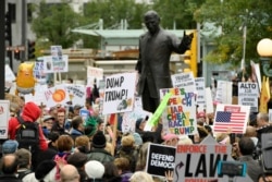 Protesters gather across the Chicago River from the Trump International Hotel and Tower while President Trump attends a fundraiser, Oct. 28, 2019, in Chicago.