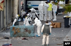 Forensics of the French police search for evidences outside a building in the northern Paris suburb of Saint-Denis, on Nov. 18, 2015, where French Police special forces raided an appartment,