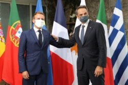 French President Emmanuel Macron welcomes Greece's Prime Minister Kyriakos Mitsotakis ahead of the plenary session of the MED7 Mediterranean countries summit, in Porticcio, Corsica, France, Sept. 10, 2020.