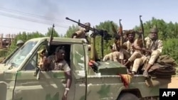 FILE - In this image grab from handout video footage released by the Sudanese paramilitary Rapid Support Forces (RSF) on April 23, 2023, fighters ride in the back of a pickup truck in the East Nile district of greater Khartoum, Sudan.