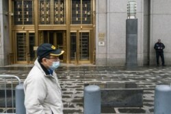 FILE - A man wearing a face mask passes by the Southern District of New York Federal courthouse during the outbreak of coronavirus disease, in New York City, New York, March 17, 2020.