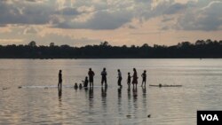 រូប​ឯកសារ៖ ប្រជាជនដើរលេងក្នុងទឹកទន្លេមេគង្គ ក្នុងខេត្តស្ទឹងត្រែង នាពេលថ្ងៃលិច កាលពីថ្ងៃទី២០ ខែកក្កដា ឆ្នាំ២០២០។ (ស៊ុន ណារិន/វីអូអេ)