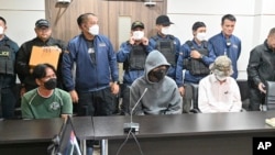 Deretan depan, dari kiri ke kanan: Suwannahong Promkanajarn, Akarawit Jaithong dan Piyabut Pienpitak dalam konferensi pers di Bangkok, Thailand, Kamis, 5 Oktober 2023. Polisi Thailand menangkap tiga pria sehubungan dengan penembakan di mal kelas atas Bangkok. (AP/Surat Sappkun)