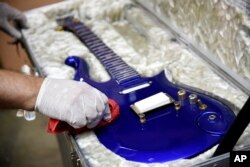 Gitar "awan" biru yang dibuat khusus pada 1980-an untuk mendiang musisi Prince dipoles di gudang Julien's Auctions sebelum dilelang (foto: dok).
