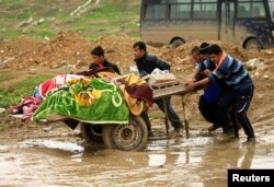 Relatives carry the bodies of civilians killed in air strikes during a battle between Iraqi forces and Islamic State militants, in Mosul, Iraq, March 17, 2017.