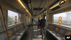 Workers sanitize Delhi metro coaches after it completes a round in Gurugram on the outskirts of New Delhi, India, Sept. 7, 2020.