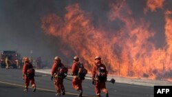Petugas bersiap memadamkan kebakaran yang terjadi di Lembah Simi, sekitar 64 km dari pusat kota Los Angeles, California, Rabu (30/10). 