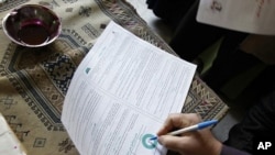An Egyptian man fills in his ballot indicating "Yes" at a polling station during voting for a referendum on constitutional amendments at a polling station in Cairo (March 2011 file photo)
