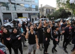 High school students shout slogans against their final high school exams, which are used as university entrance exams, outside their school in Santiago, Chile, Tuesday, Jan. 7, 2020.