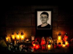 FILE - Candles and a portrait of Slovak investigative journalist Jan Kuciak.