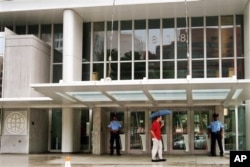 FILE - Private security guards stand at the entrance of the headquarters of the World Bank, in Washington, Aug. 1, 2004.
