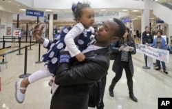 FILE - Abdisellam Hassen Ahmed, a Somali refugee who had been stuck in limbo after President Donald Trump temporarily banned refugee entries, holds his 2-year-old daughter, Taslim, after meeting her for the first time upon arriving at Salt Lake International Airport in Salt Lake City, Utah, Feb. 10, 2017.