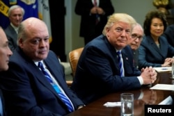 U.S. President Donald Trump, flanked by Ford CEO James Hackett, left, and White House chief economic adviser Larry Kudlow, 2nd right, and Transportation Secretary Elaine Chao, meets with chief executives of major U.S. and foreign automakers at the White House in Washington, May 11, 2018.