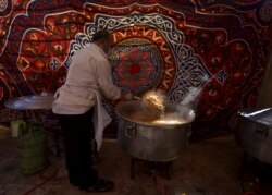 Abdul Rahman al-Shobaki, salah seorang sukarelawan, ikut menyiapkan makanan untuk dibagikan kepada orang-orang yang membutuhkan selama bulan suci Ramadan, di tengah pandemi COVID-19, di Maan, Yordania 1 Mei 2021. (REUTERS / Muath Freij)