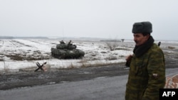 Seorang tentara separatis pro-Rusia berjaga-jaga di Pos Keamanan di Enakieve, 25 km dari kota timur Rusia, Debaltseve (29/1). 