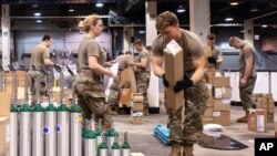 FILE - This March 30, 2020, photo provided by the Illinois Air National Guard shows members of the Guard assembling medical equipment in response to the COVID-19 coronavirus pandemic in Chicago.