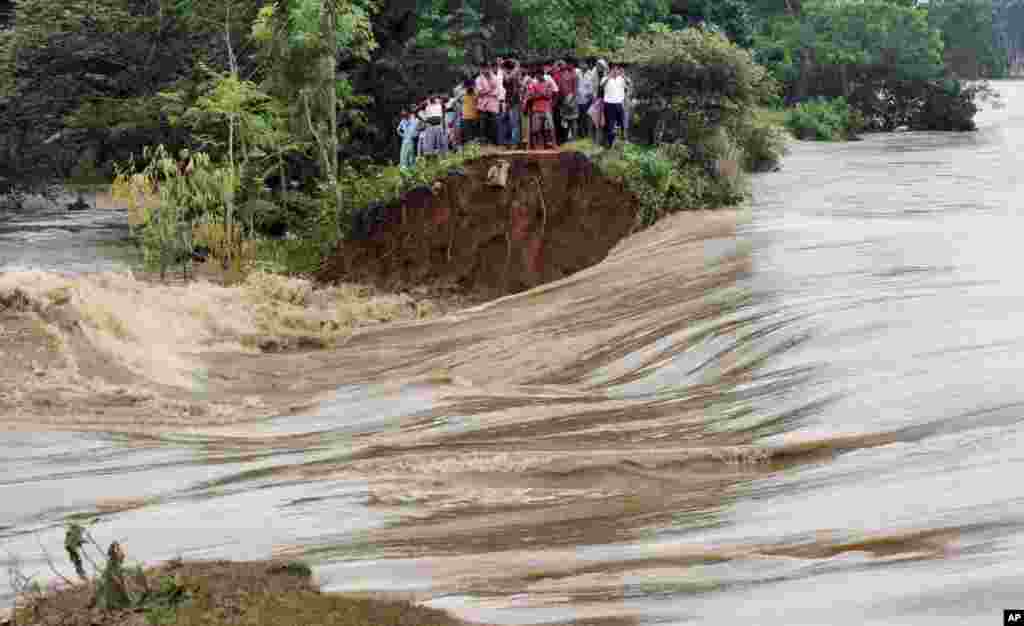 Warga desa di India berdiri di sebuah tanggul sungai Kangsabati yang meluap, di Desa Samat, negara bagian Benggala Barat.