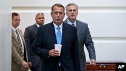 Ketua DPR AS John Boehner, R-Ohio, bersama anggota DPR dari Partai Republik Kevin McCarthy, berjalan menuju ruang pertemuan di gedung Capitol (15/10). (AP/J. Scott Applewhite)