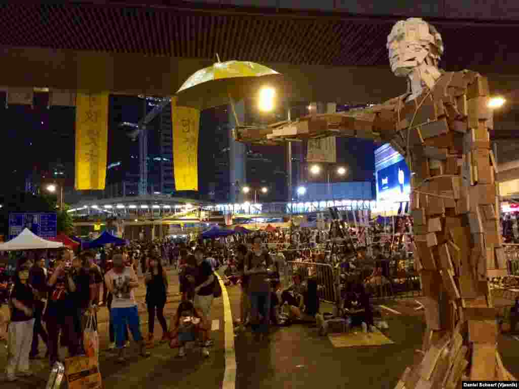 A wood art sculpture titled "Umbrella Man" sits amidst the Hong Kong Occupy Central protest area, Oct. 5, 2014.