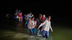 Obitelji migranata, uglavnom iz zemalja Srednje Amerike, probijaju se plitkim vodama nakon što su ih krijumčari isporučili na malim splavovima na napuhavanje na tlu SAD-a u Romi u Teksasu, 24. marta 2021.