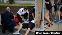 资料照片：美国波士顿郊区一名用药过量的男子正在接受抢救（2017年8月23日）