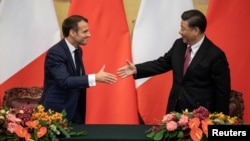 法国总统马克龙与中国国家主席习近平在北京人大会堂的签约仪式上握手。（2019年11月6日）