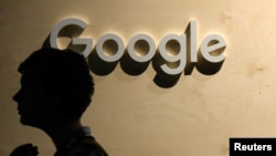 FILE - A woman passes the logo from the web search engine provider Google during the digital society festival 're:publica', at the Arena Berlin in Berlin, Germany June 9, 2022. (REUTERS/Annegret Hilse)