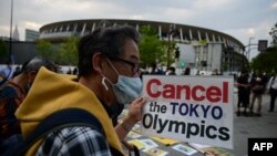 FILE - People take part in a protest against the hosting of the 2020 Tokyo Olympic Games outside the Olympic museum in Tokyo on May 9, 2021. (AFP)