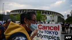 Des gens participent à une manifestation contre l'organisation des Jeux Olympiques de Tokyo 2020 devant le musée olympique de Tokyo le 9 mai 2021 (Photo de Philip FONG / AFP)