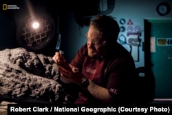 Royal Tyrrell Museum's Mark Mitchell slowly frees the nodosaur’s foot and footpad from the surrounding rock. (Credit: Robert Clark / National Geographic)