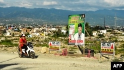Dua orang warga yang mengendarai sepeda motor melewati baliho pemilu bergambar seorang Caleg di Palu, Sulawesi Tengah (foto: ilustrasi). 