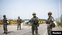 ទាហាន​កូរ៉េ​ខាង​ត្បូង​ឈរ​យាម​នៅ​ច្រក​នៅ​លើ​ស្ពាន​បង្រួបបង្រួម​កូរ៉េ​ដែល​ឆ្លង​ទៅ​ដល់​ភូមិ​ Panmunjom​ ដែល​ជា​ភូមិ​ត្រូវ​បាន​ផ្អាក​ធ្វើ​សង្រ្គាម​ ដែល​ស្ថិត​នៅ​ភាគ​ខាងត្បូង​នៃ​តំបន់​គ្មាន​យោធា​ដែល​ខណ្ឌ​ចែក​កូរ៉េ​ទាំង​ពីរ​នៅ​ទី​ក្រុង​Paju​ ប្រទេស​កូរ៉េ​ខាងត្បូង​ថ្ងៃ​ទី​២៤​ខែ​សីហា​ឆ្នាំ​២០១៥ ។