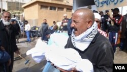 Seorang warga Libya membawa bagian tubuh jenazah demonstran yang menjadi korban kekerasan oleh pasukan keamanan Libya di Benghazi (21/2). Diperkirakan lebih dari 200 orang tewas dalam kekerasan di Benghazi.