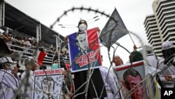 Ribuan warga berunjuk rasa sambil memegang poster yang mengutuk Presiden Prancis Emmanuel Macron di luar Kedutaan Besar Perancis di Jakarta, Indonesia, Senin, 2 November 2020.(AP Photo/Dita Alangkara)
