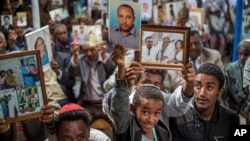 FILE - Members of Ethiopia's Jewish community hold up pictures of their relatives in Israel, during a solidarity event at a synagogue in Addis Ababa, Ethiopia, Feb. 28, 2018.