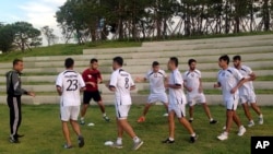 FILE - Palestinian football players warm-up during a training session at the Asian Games athletes’ village in Incheon, South Korea.