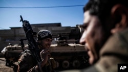 Tentara Irak dari Divisi Infantri 9 membawa sejata mesin saat menuju garis depan di Mosul, Irak (6/12). 