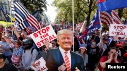 Des partisans du président américain Donald Trump brandissent son effigie lors d'une manifestation à Atlanta, en Géorgie, le 21 novembre 2020.