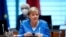 German Chancellor Angela Merkel removes her mask, at the beginning of a Federal Cabinet meeting at the Federal Chancellery, in Berlin, Sept. 8, 2021. 