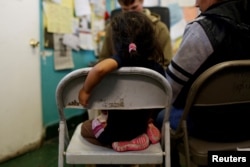 FILE - An undocumented immigrant family from Guatemala talks to a volunteer after their arrival to Announciation House, an organization that provides shelter to immigrants and refugees, in El Paso, Texas, Jan. 17, 2017.